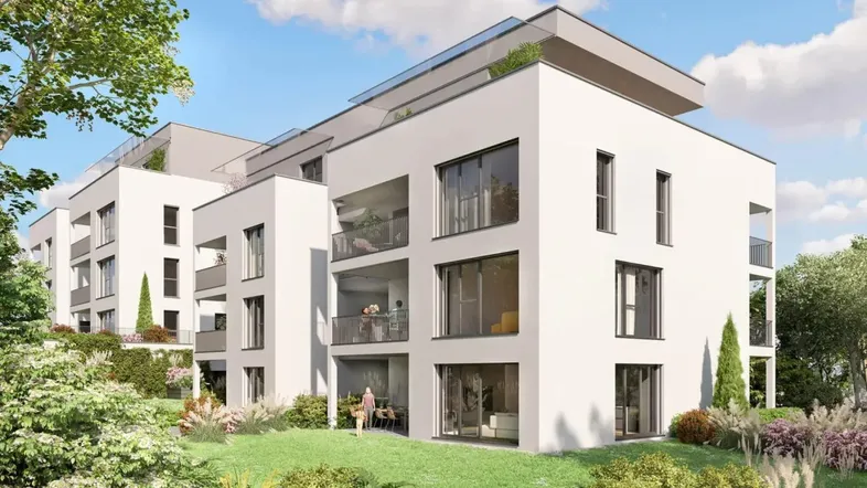 Moderne Wohnanlage mit weißer Fassade, großen Fenstern und begrünten Außenbereichen.