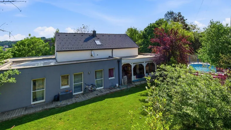 Blick auf das Haus von hinten mit großem Garten und einem kleinen Pool im Grünen.