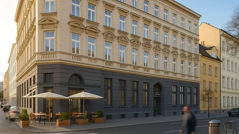 Elegantes Eckgebäude mit klassischer Architektur und Außengastronomie an einer belebten Straße.