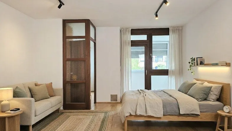 Virtuell eingerichtetes Zimmer mit Holzboden, Bett und Sofa, beleuchtet von modernen Deckenspots.
