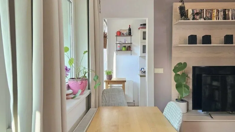 Heller Wohnbereich mit Esstisch und Blick in die angrenzende Küche, ideal für geselliges Beisammensein.