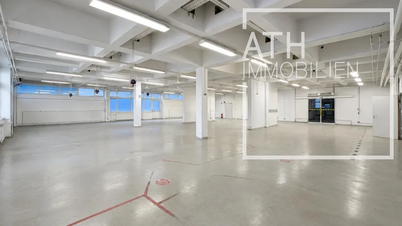 Geräumige, leere Lagerhalle mit hohen Decken, Betonboden und großen Fenstern, bereit zur Nutzung.