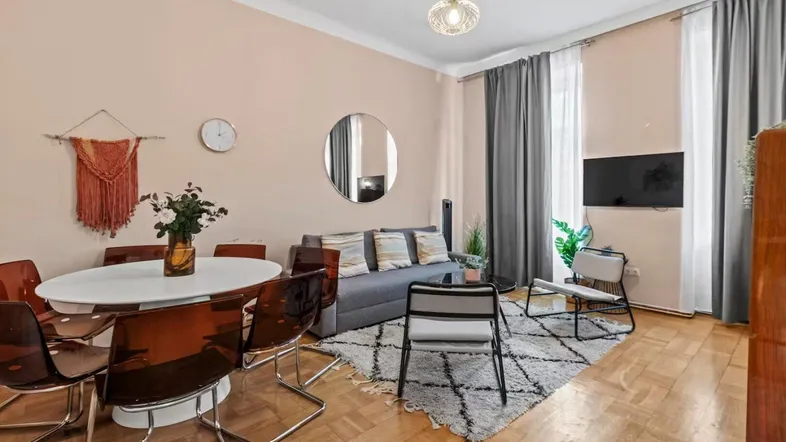 Heller Wohn- und Essbereich mit Parkettboden, gemütlichem Sofa und modernem Esstisch.