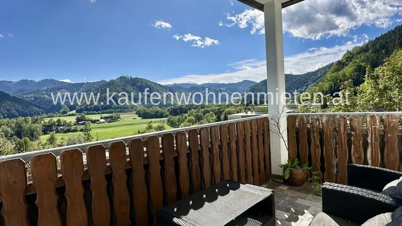 Geräumiger Balkon mit Holzzaun und atemberaubendem Bergblick, ideal zum Entspannen im Freien.