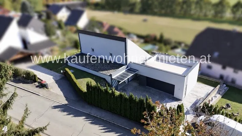 Moderne Architektur mit Flachdach und gepflegter Außenanlage in einer ruhigen Wohngegend.