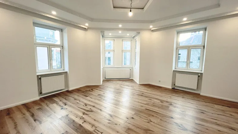Helles, geräumiges Zimmer mit modernem Parkettboden, dekorativer Decke und Einbaustrahlern.