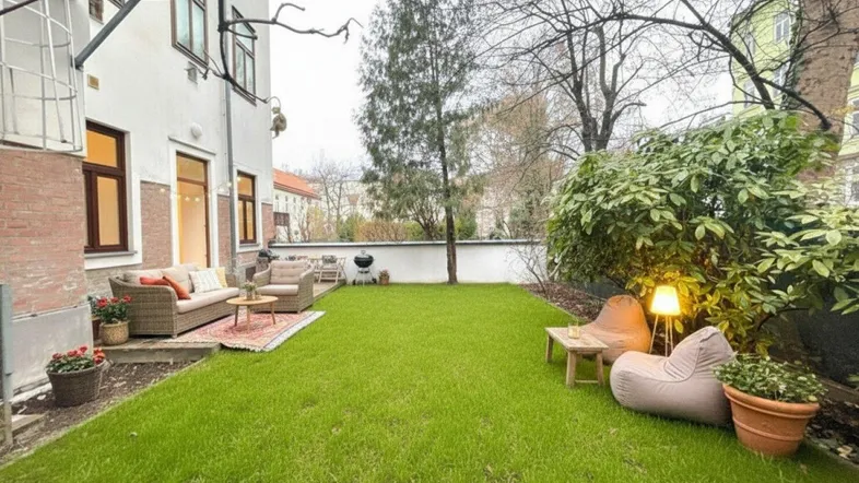 Gepflegter Gartenbereich mit Rasenfläche und gemütlicher Outdoor-Sitzgruppe für entspannte Stunden im Freien.