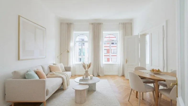 Helles Wohn- und Esszimmer mit Fischgrätparkett, modernen Möbeln und hohen Bogenfenstern.