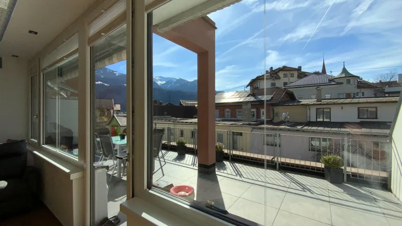 Blick vom Wohnzimmer auf die sonnige Terrasse mit Bergblick.