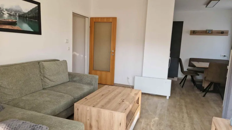 Gemütliches Wohnzimmer mit Sofa, Couchtisch und Zugang zum Essbereich.