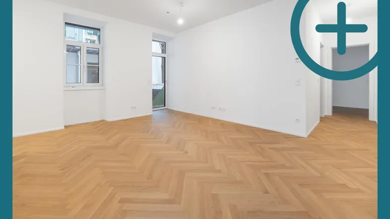 Helles Zimmer mit Fischgrätparkett und Zugang zu einem kleinen Balkon oder Austritt.