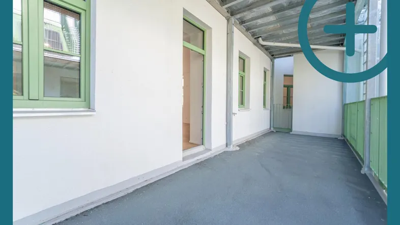 Lange, überdachte Loggia mit grün gestrichenen Fensterrahmen und Geländer, ideal für entspannte Stunden im Freien.