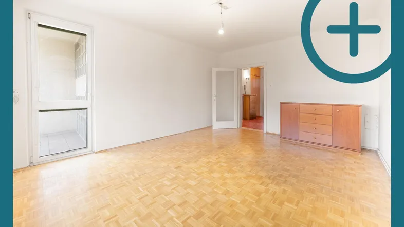 Helles, leeres Zimmer mit Parkettboden, weißen Wänden und Zugang zu einem verglasten Balkon.