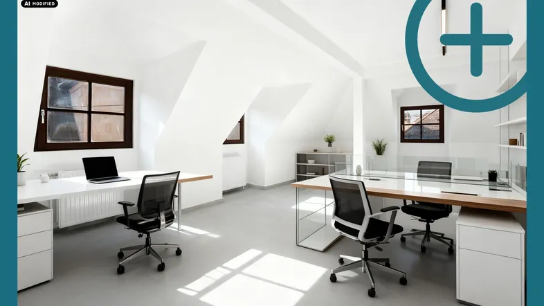 Helles Dachgeschossbüro mit modernen Arbeitsplätzen, Schreibtischen und Bürostühlen unter schrägen Decken.
