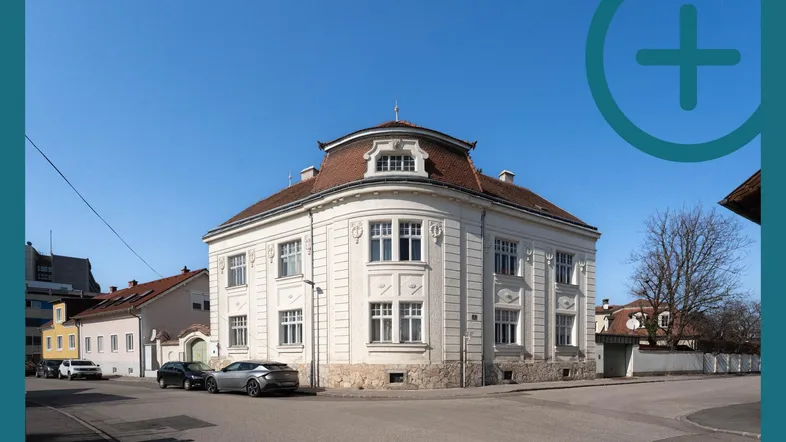 Historisches Gebäude mit markanter Architektur und runden Fenstern an einer Straßenecke.