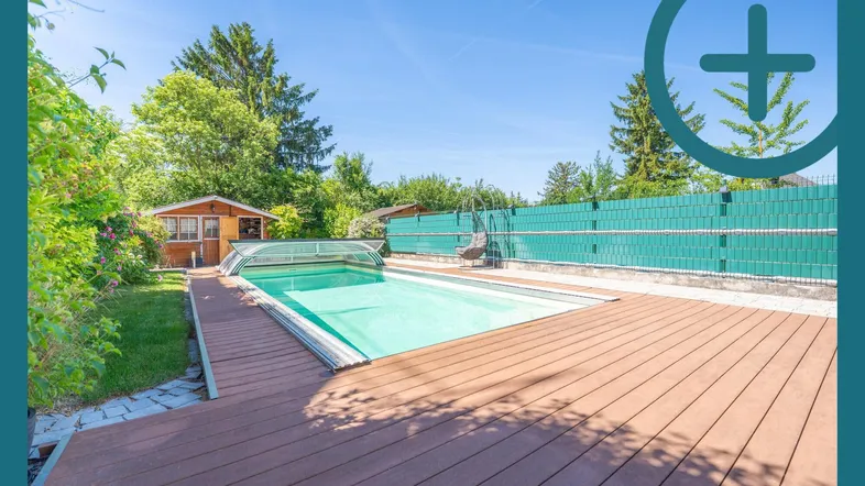 Sonniger Außenbereich mit großem Swimmingpool, Holzdeck und umgebendem Garten.