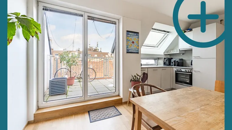 Heller Wohn- und Essbereich mit offener Küche, Holzboden und Zugang zu einer Dachterrasse.