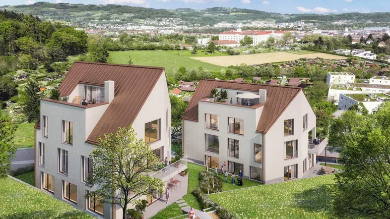 Moderne Wohngebäude in grüner Hanglage mit weitem Blick über die Landschaft und die Stadt.