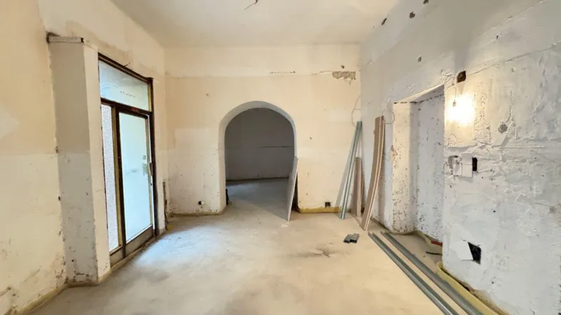 Unfertiger Innenraum mit freigelegten Wänden und Betonboden, bereit für den weiteren Ausbau.