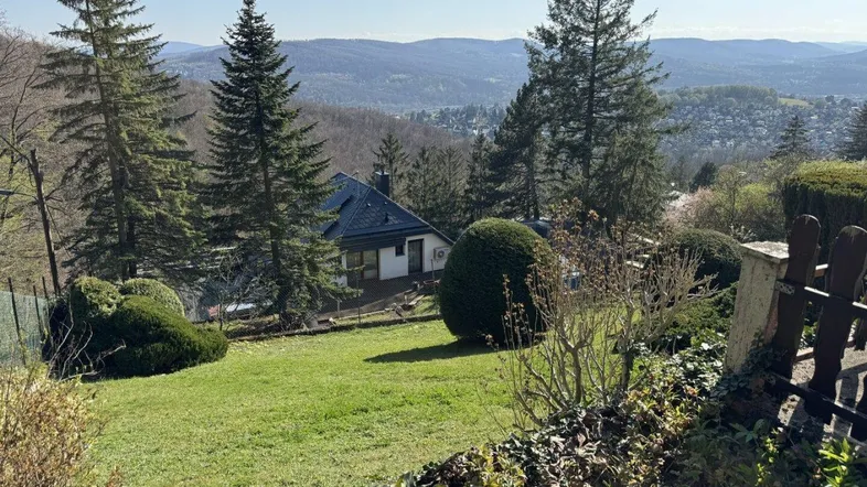 Weitläufiger Gartenbereich mit gepflegtem Rasen und einem malerischen Blick auf die umliegende Hügellandschaft.