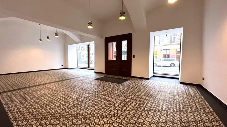 Geräumiger Eingangsbereich eines Gewerberaums mit hohen Gewölbedecken und gemusterten Fliesenböden.