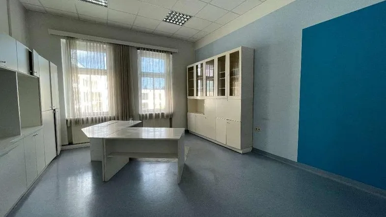 Geräumiges Büro mit großen Fenstern, Einbauschränken und einem modernen Schreibtisch, ideal für produktives Arbeiten.