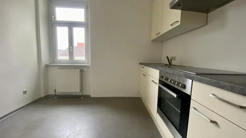 Helle Küche mit Einbauküche, Fenster und modernem Bodenbelag, bereit zur Nutzung.