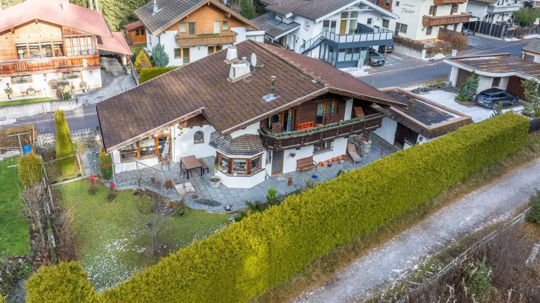 Großzügiges Einfamilienhaus mit gepflegtem Garten, Terrasse und umliegender Wohnbebauung.