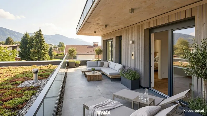 Geräumige Terrasse mit modernen Loungemöbeln, Liegestühlen und weitem Bergblick.