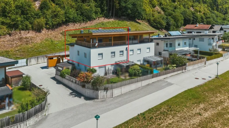 Luftaufnahme des modernen Gebäudes mit Solaranlage auf dem Dach und grüner Umgebung.
