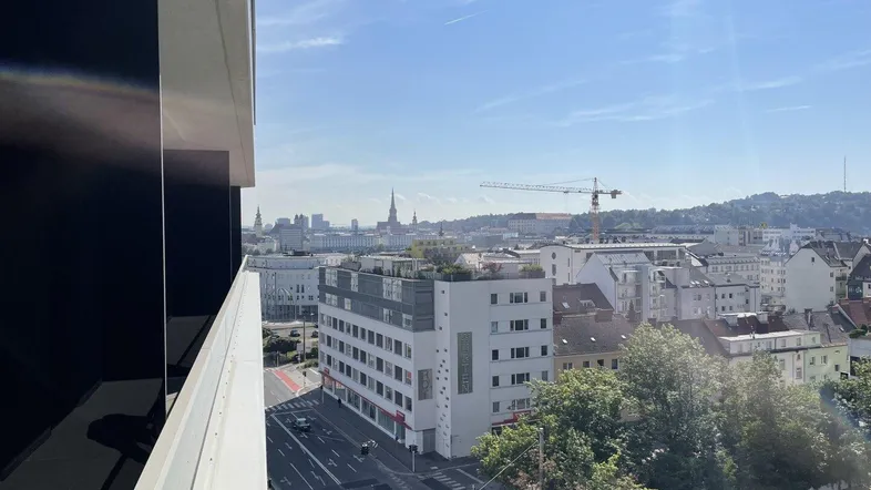 Stadtansicht von einem Balkon mit Blick auf Gebäude und den Himmel.