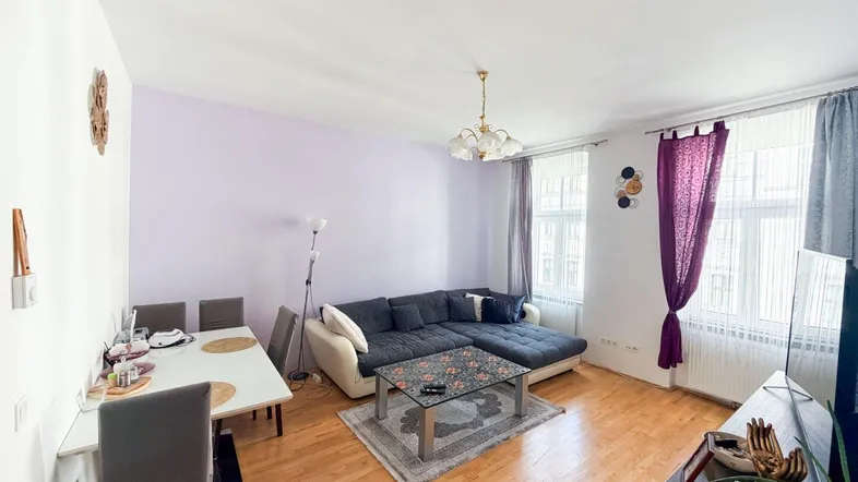 Heller Wohn- und Essbereich mit gemütlichem Sofa, Esstisch und Parkettboden.