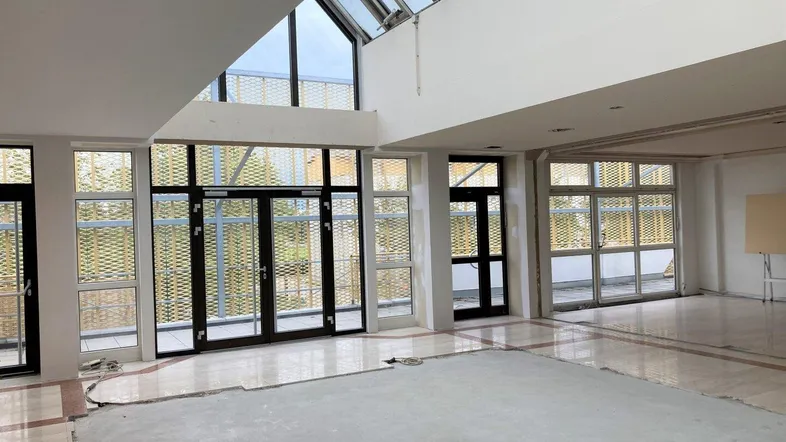 Großer Innenraum mit beeindruckendem Glasdach und vielen Fenstern, ideal für zukünftige Gewerbeflächen.