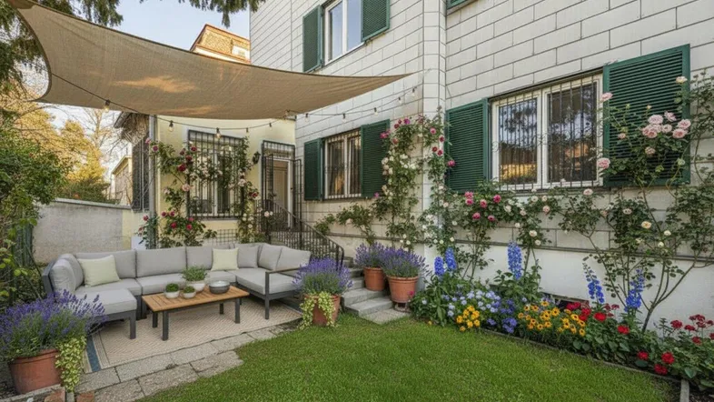 Gemütlicher Gartenbereich mit bequemen Outdoor-Möbeln, Sonnensegel und blühenden Pflanzen.