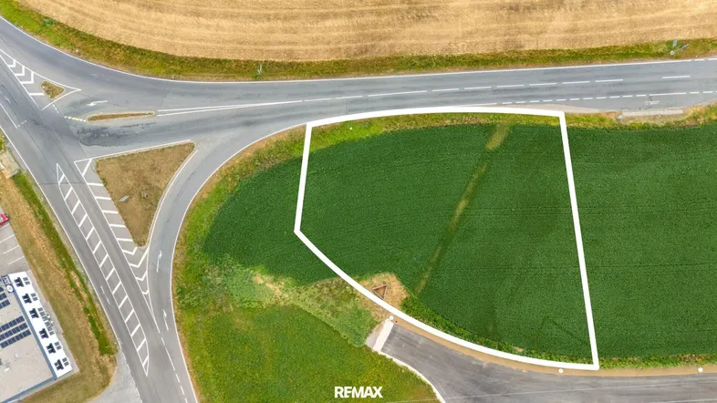 Luftaufnahme eines Grundstücks, umgeben von Feldern und einer Straße, ideal für eine neue Entwicklung.