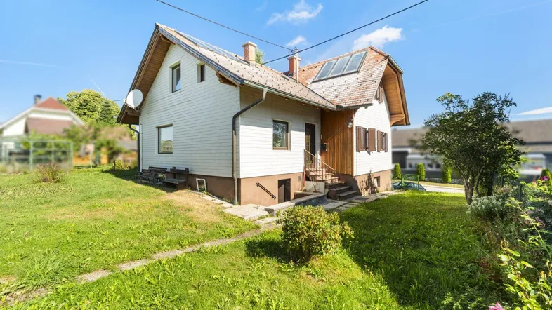 Freistehendes Einfamilienhaus mit Satteldach, Solaranlage und gepflegtem Vorgarten.
