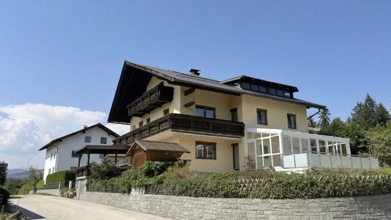 Traditionelles Haus mit Wintergarten und Balkonen in sonniger Lage.