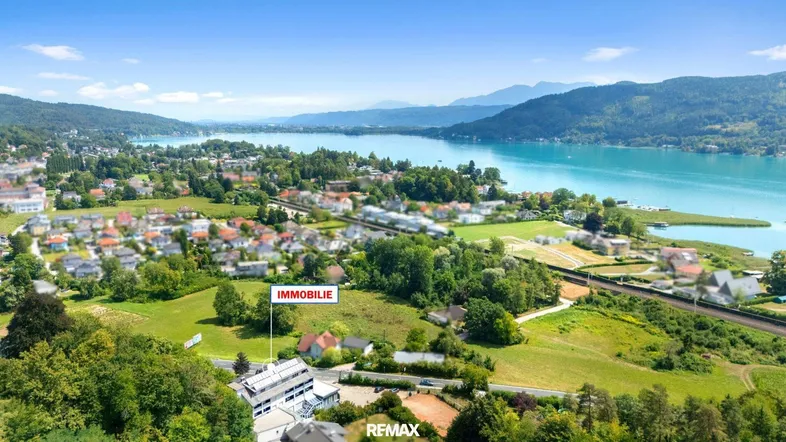 Luftaufnahme der Immobilie in malerischer Umgebung mit See- und Bergblick.