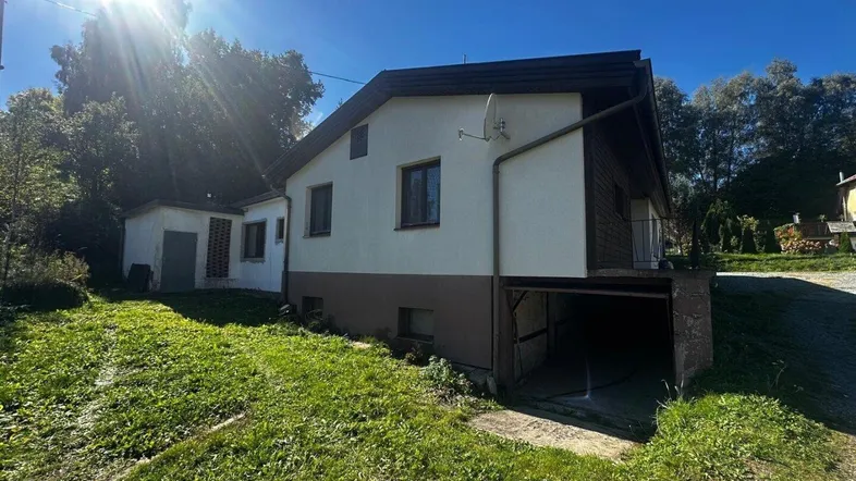 Einfamilienhaus mit großem Garten, Carport und sonniger Lage in ländlicher Umgebung.