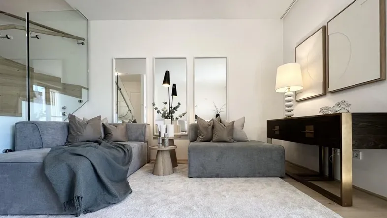 Modernes Wohnzimmer mit bequemen Sofas, Teppichboden und stilvoller Dekoration.