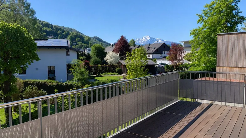 Geräumiger Balkon mit Holzboden und weitem Blick auf die umliegende Berglandschaft.