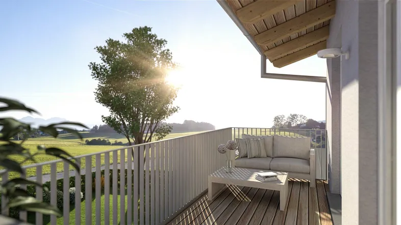 Sonniger Balkon mit Holzboden und bequemen Outdoor-Möbeln, umgeben von grüner Landschaft.