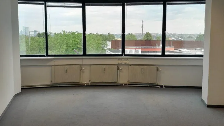 Geräumiges Büro mit großen Panoramafenstern, die einen weiten Blick auf die Umgebung bieten und viel Tageslicht hereinlassen.