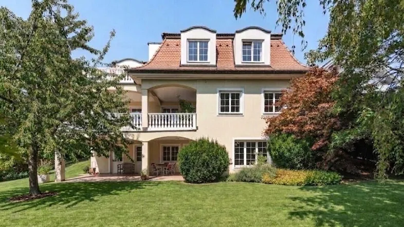 Elegante Villa mit gepflegtem Garten und mehreren Balkonen in sonniger Lage.