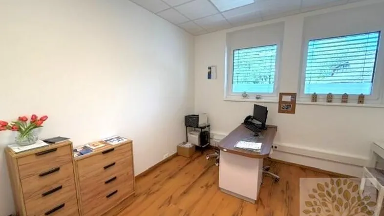 Helles Büro mit Holzschubladen, Schreibtisch und zwei Fenstern, ideal für produktives Arbeiten.