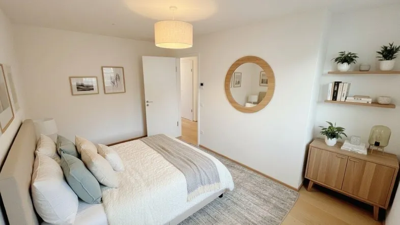 Helles Schlafzimmer mit modernem Bett, runden Spiegel und Holzmöbeln, das eine ruhige Atmosphäre schafft.