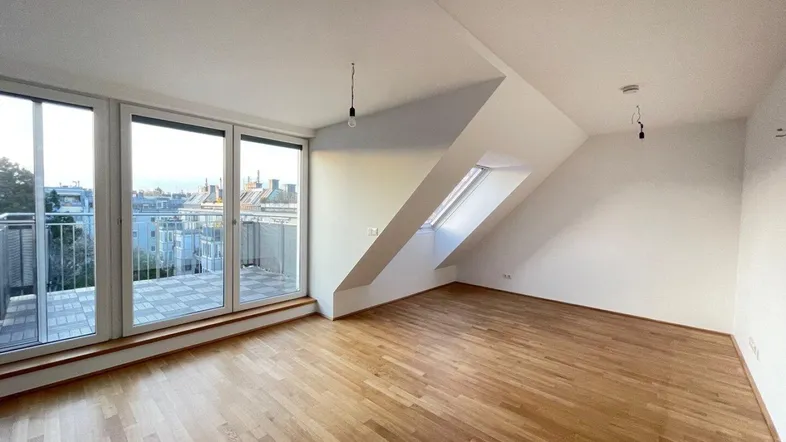 Helles Wohnzimmer mit Holzboden, großen Fenstern und Zugang zu einer Dachterrasse.