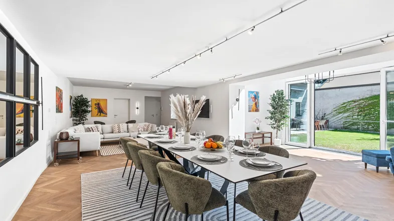 Geräumiger, lichtdurchfluteter Wohn- und Essbereich mit modernem Interieur und Zugang zum Garten.