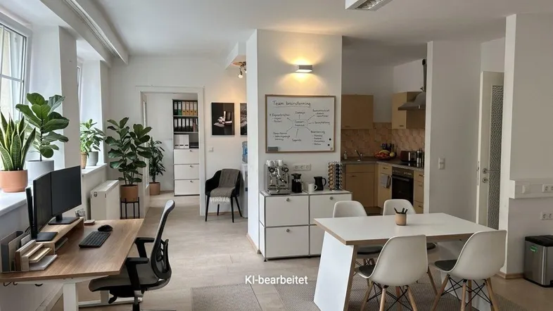 Geräumiges Großraumbüro mit mehreren Arbeitsplätzen, einem Besprechungsbereich und integrierter Teeküche, hell und modern.