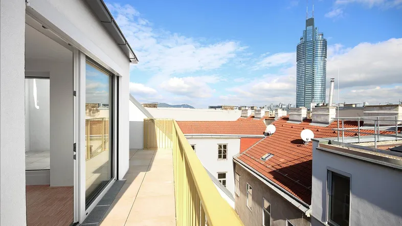 Geräumiger Balkon mit Panoramablick auf die Stadt und moderne Hochhäuser unter blauem Himmel.